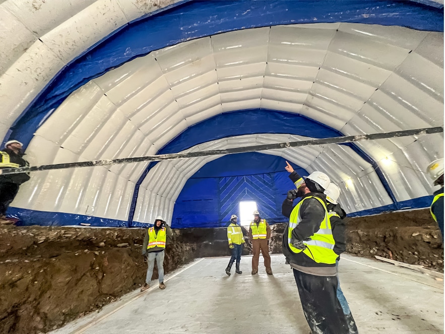 Construction workers standing inside a constant air work tent