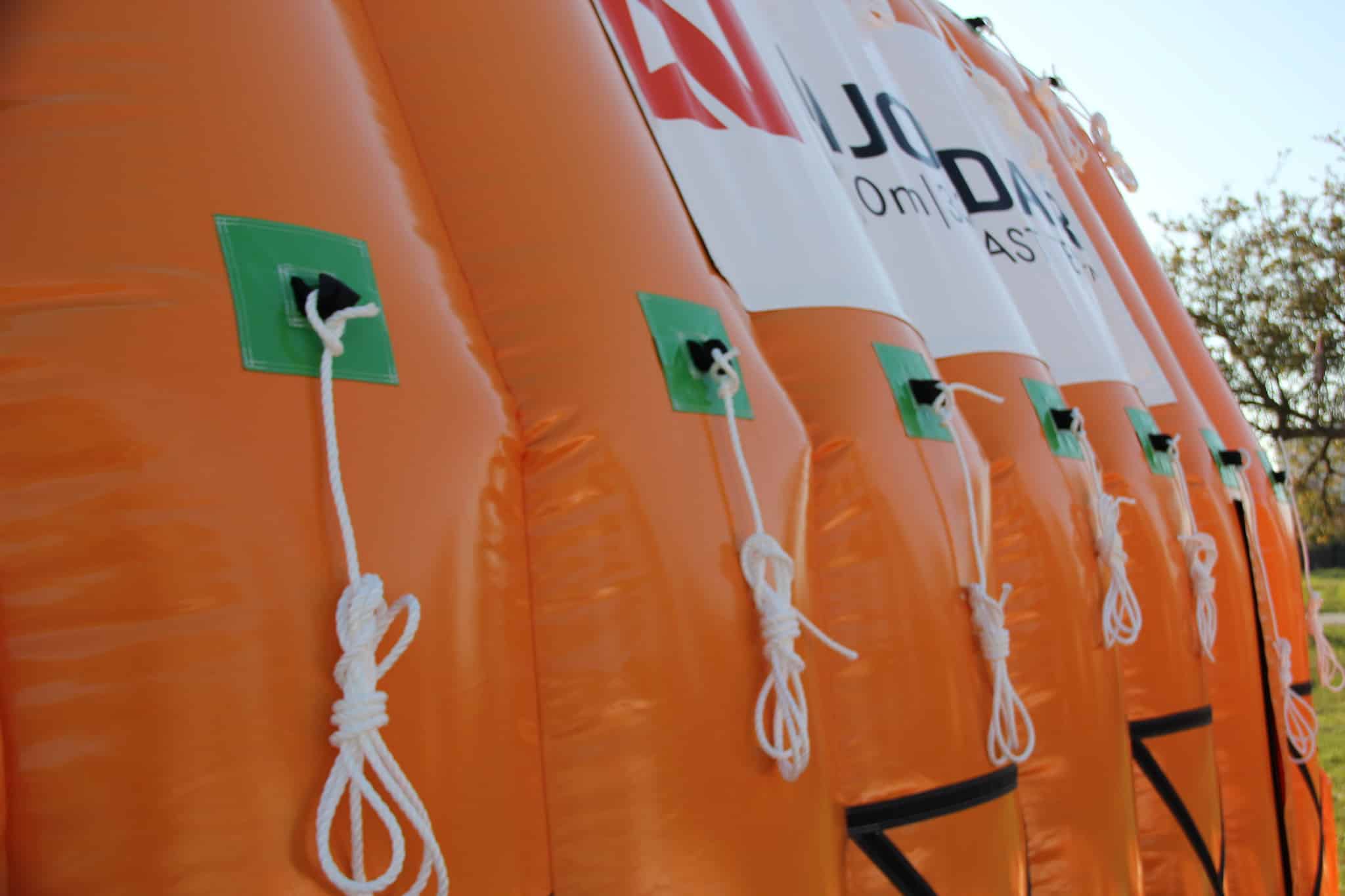 How should an inflatable building be anchored?